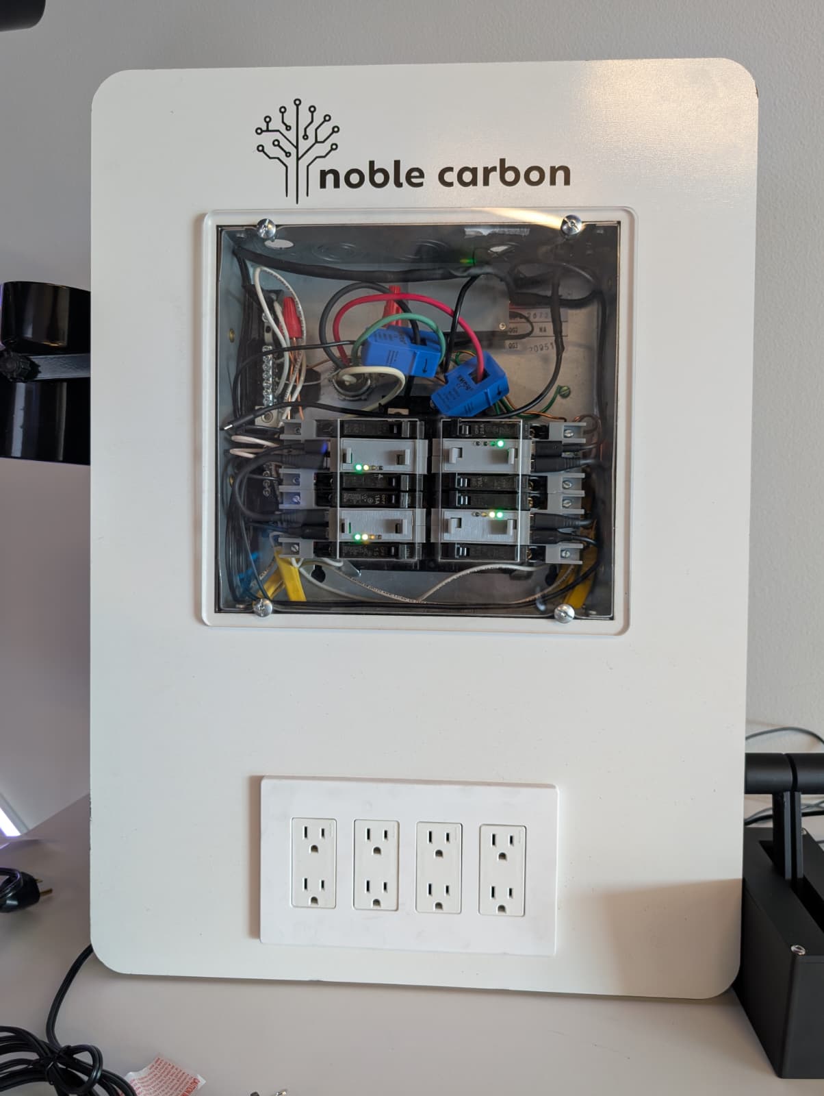 Noble Carbon smart breakers installed in a transparent demonstration panel